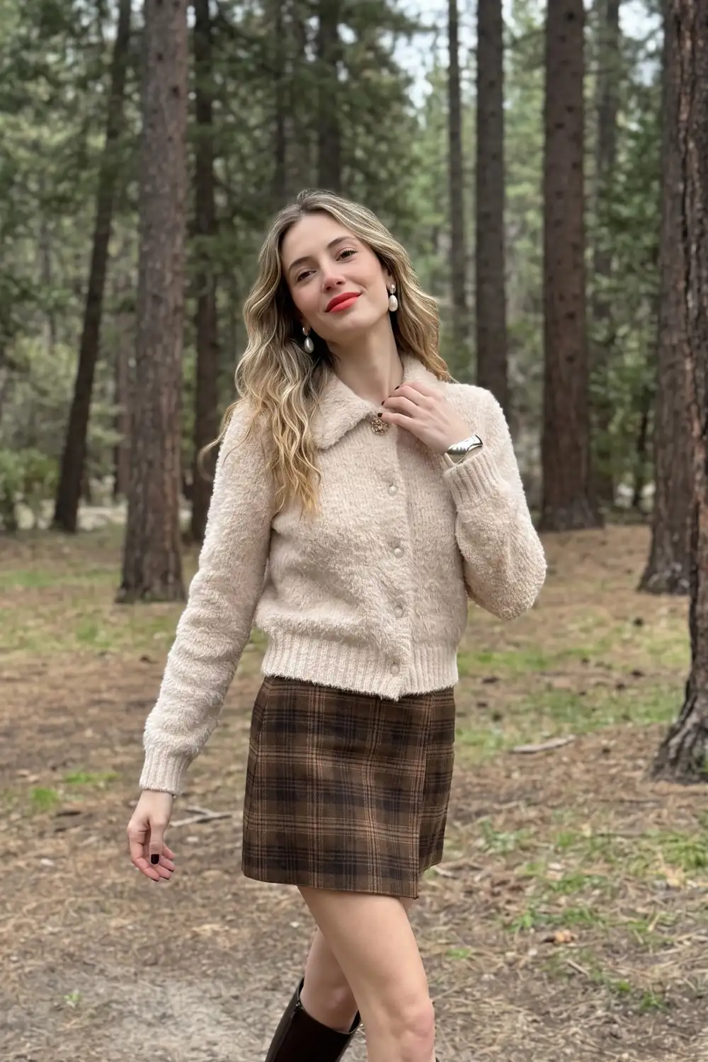 Woman in cream fluffy boucle cardigan with dark brown plaid mini skirt and knee high boots