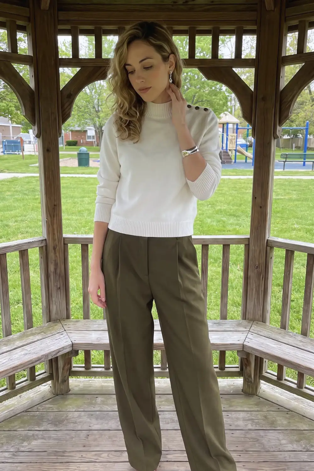 Woman in cream mock neck sweater with olive green wide leg trousers