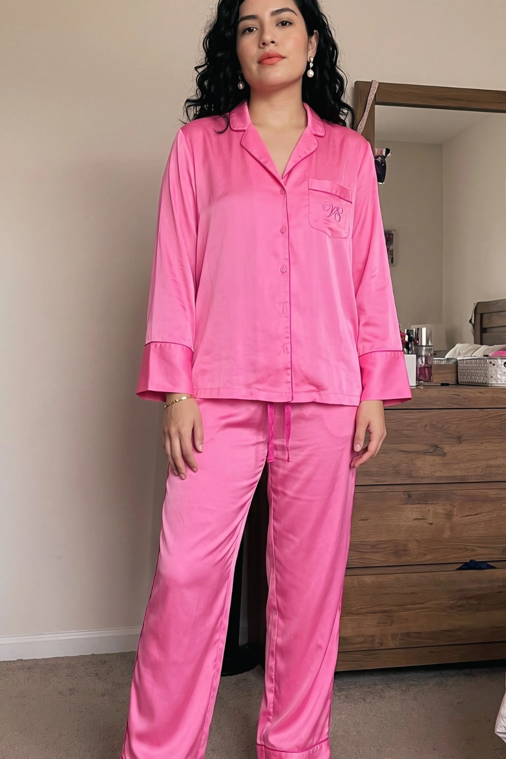 Woman in hot pink satin long sleeve button down shirt and wide leg drawstring pants pajama set