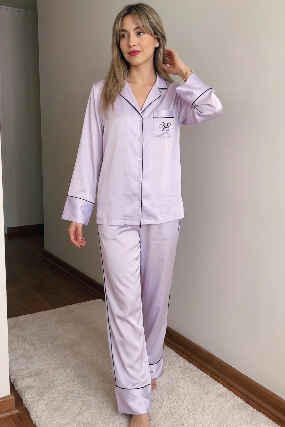 Woman in lavender satin long sleeve button down shirt with black piping trim and wide leg pants pajama set