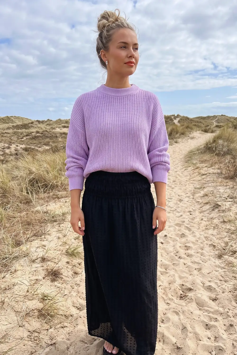 Woman in lilac chunky knit oversized sweater with black textured maxi skirt
