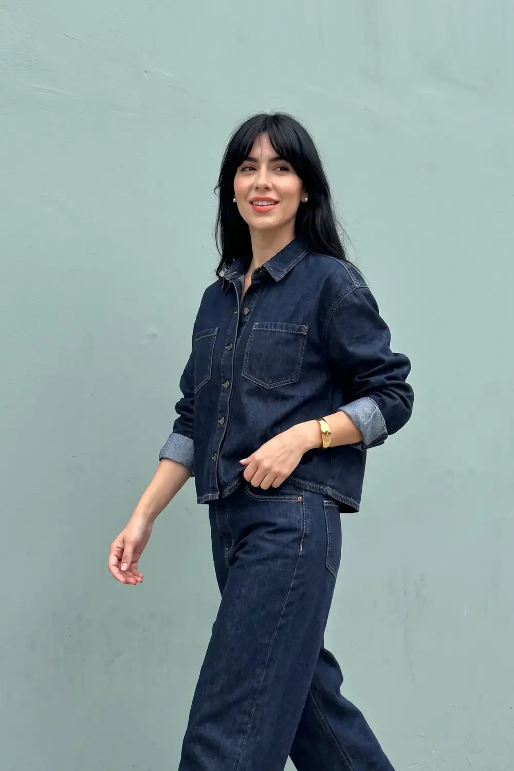 Woman in dark navy oversized denim shirt jacket with rolled cuffs and matching wide leg jeans