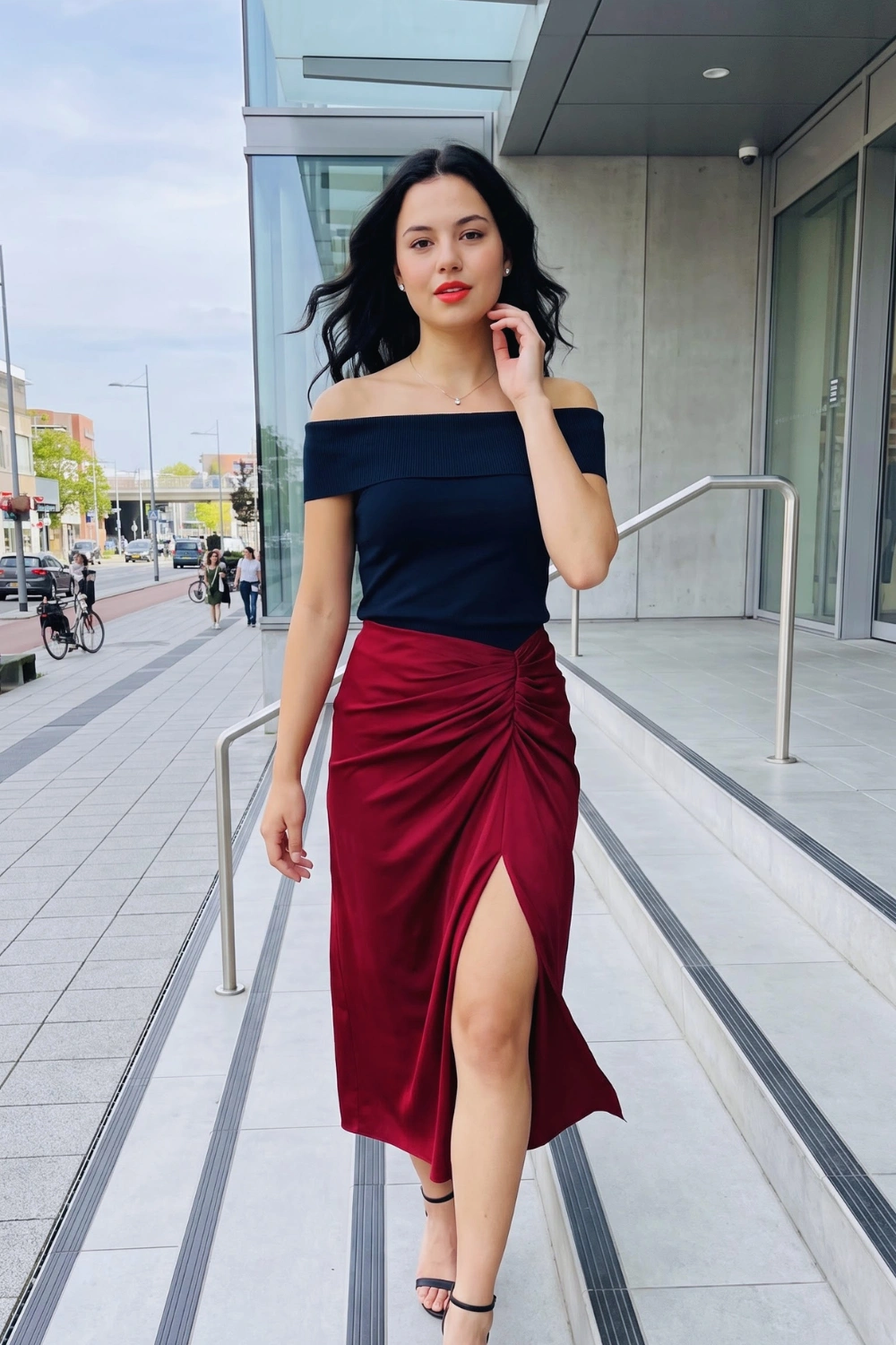 Woman in navy blue off shoulder ribbed top with burgundy satin ruched midi skirt with slit
