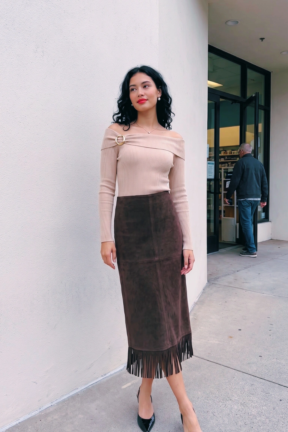 Woman in beige off shoulder ribbed knit top and dark brown suede fringe midi skirt