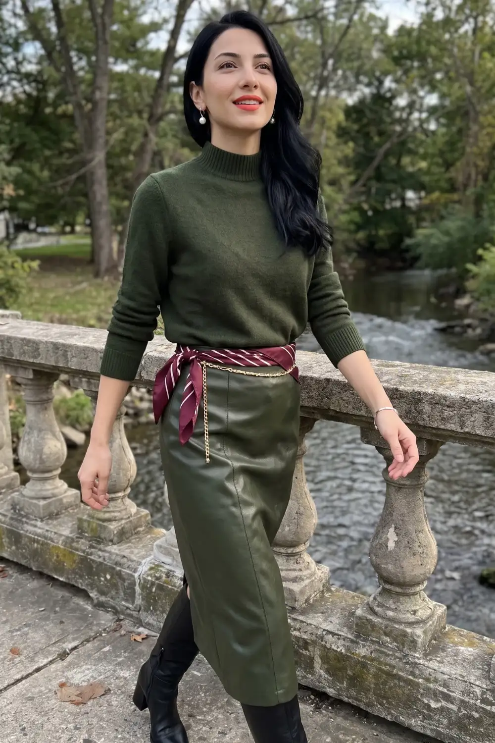 Woman in olive green mock neck sweater with olive green leather midi pencil skirt