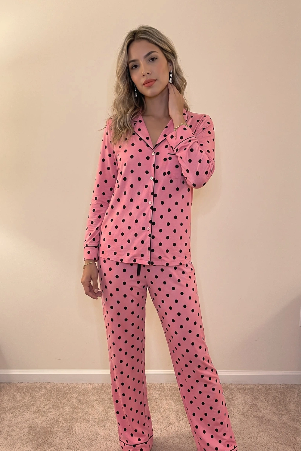 Woman in pink black polka dot long sleeve button down shirt and wide leg pants pajama set