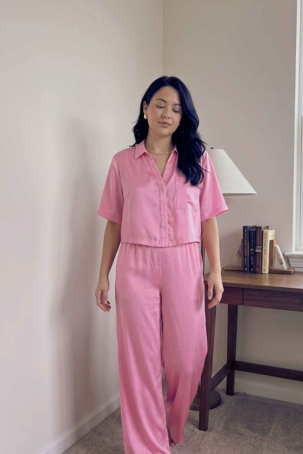 Woman in pink satin cropped short sleeve button down shirt and wide leg pants pajama set