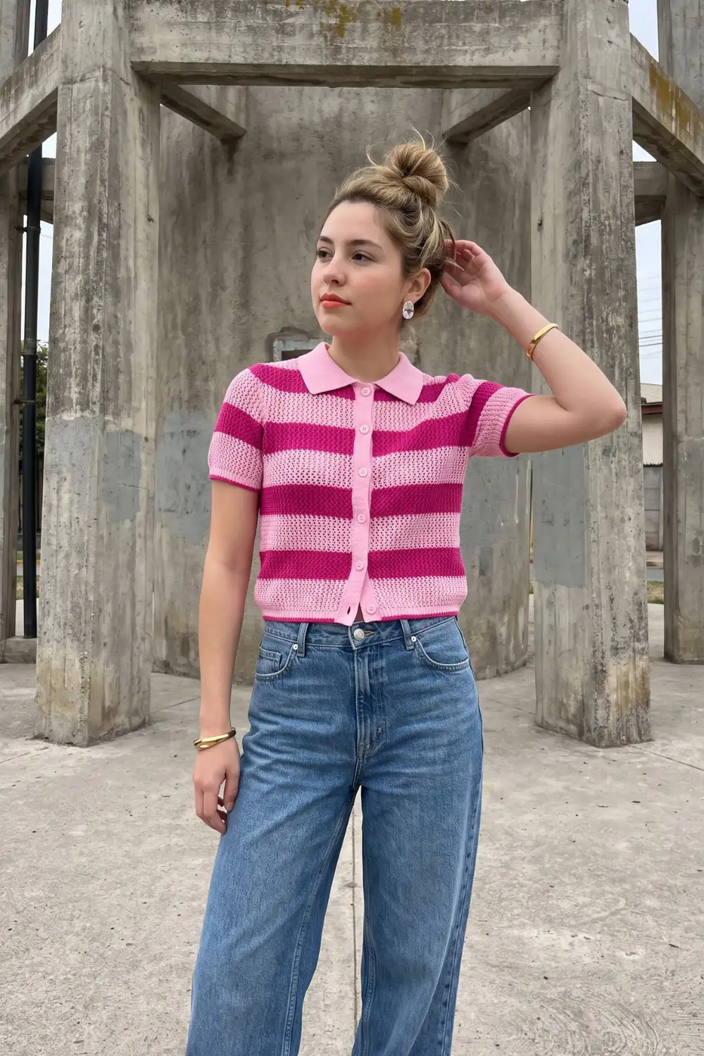 Woman in pink striped crochet polo top with wide leg blue denim jeans