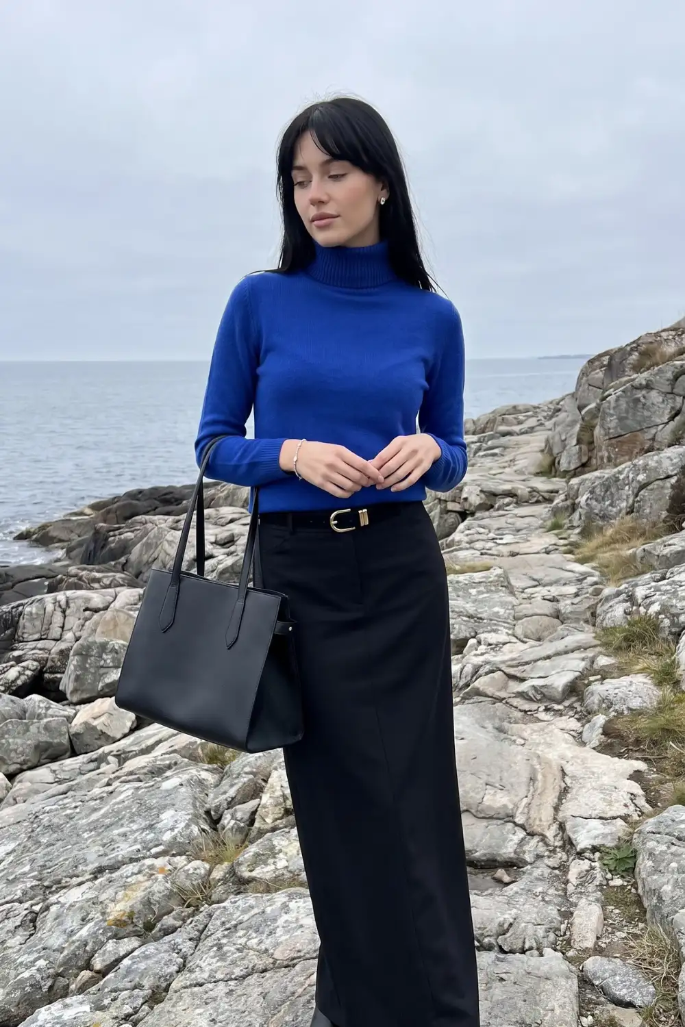 Woman in royal blue turtleneck sweater with black wide leg trousers