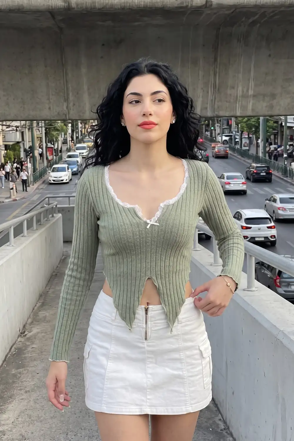 Woman in sage green ribbed lace trim crop top with white zip front cargo mini skirt