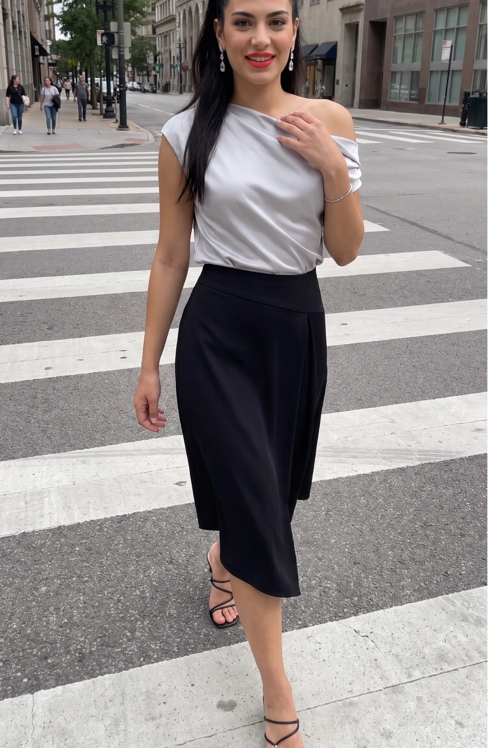 Woman in silver grey one shoulder satin top with black satin midi skirt