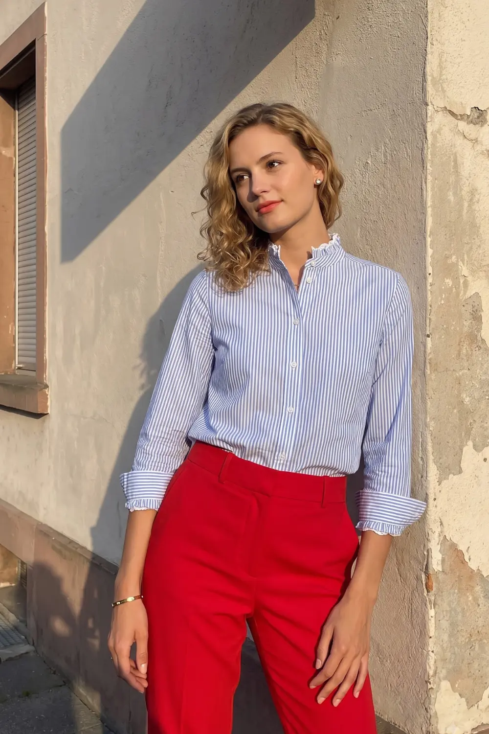 Woman in blue white stripe ruffle collar shirt and red high waist tailored trousers