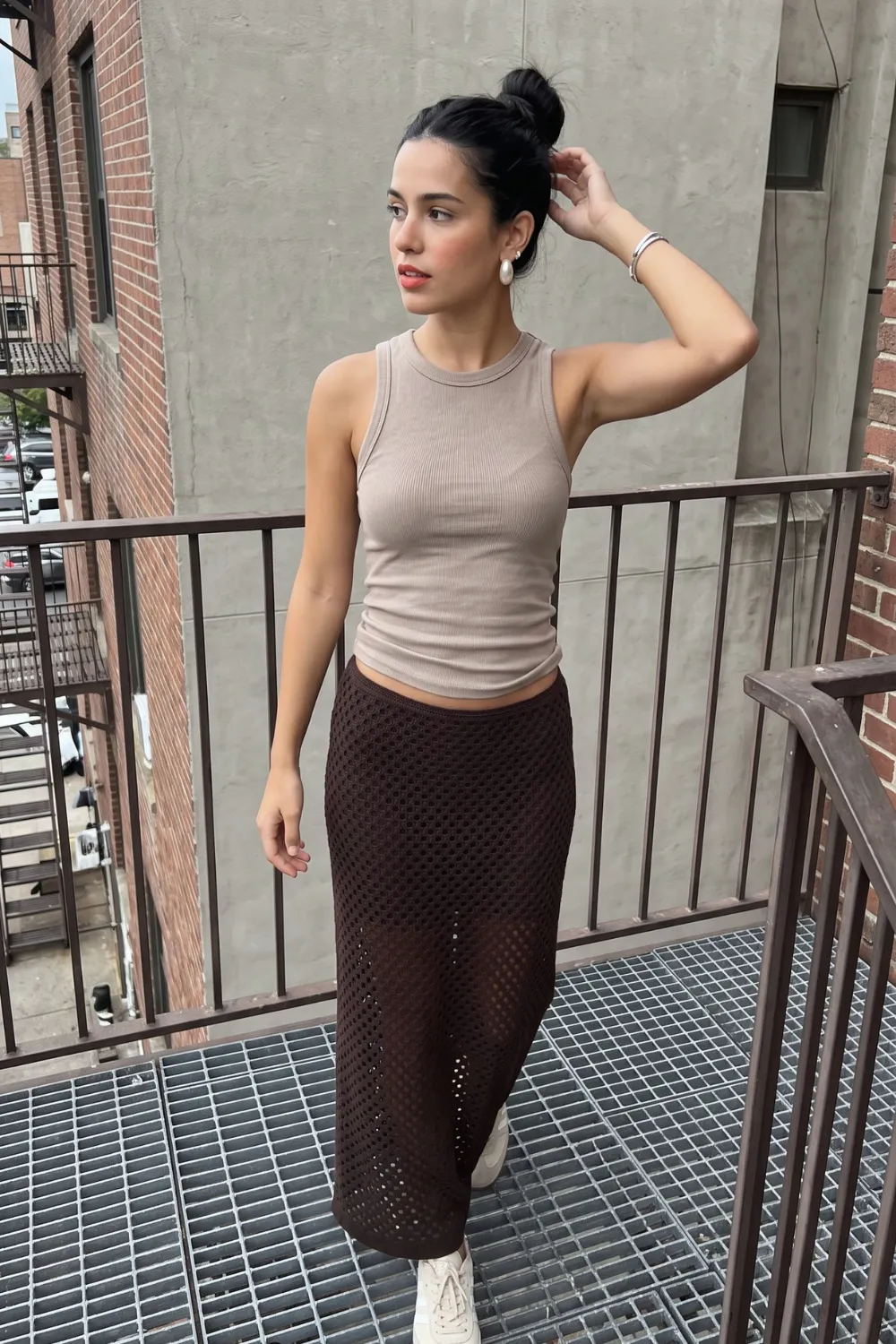 Woman in taupe ribbed sleeveless crop tank top and dark chocolate brown crochet mesh midi skirt