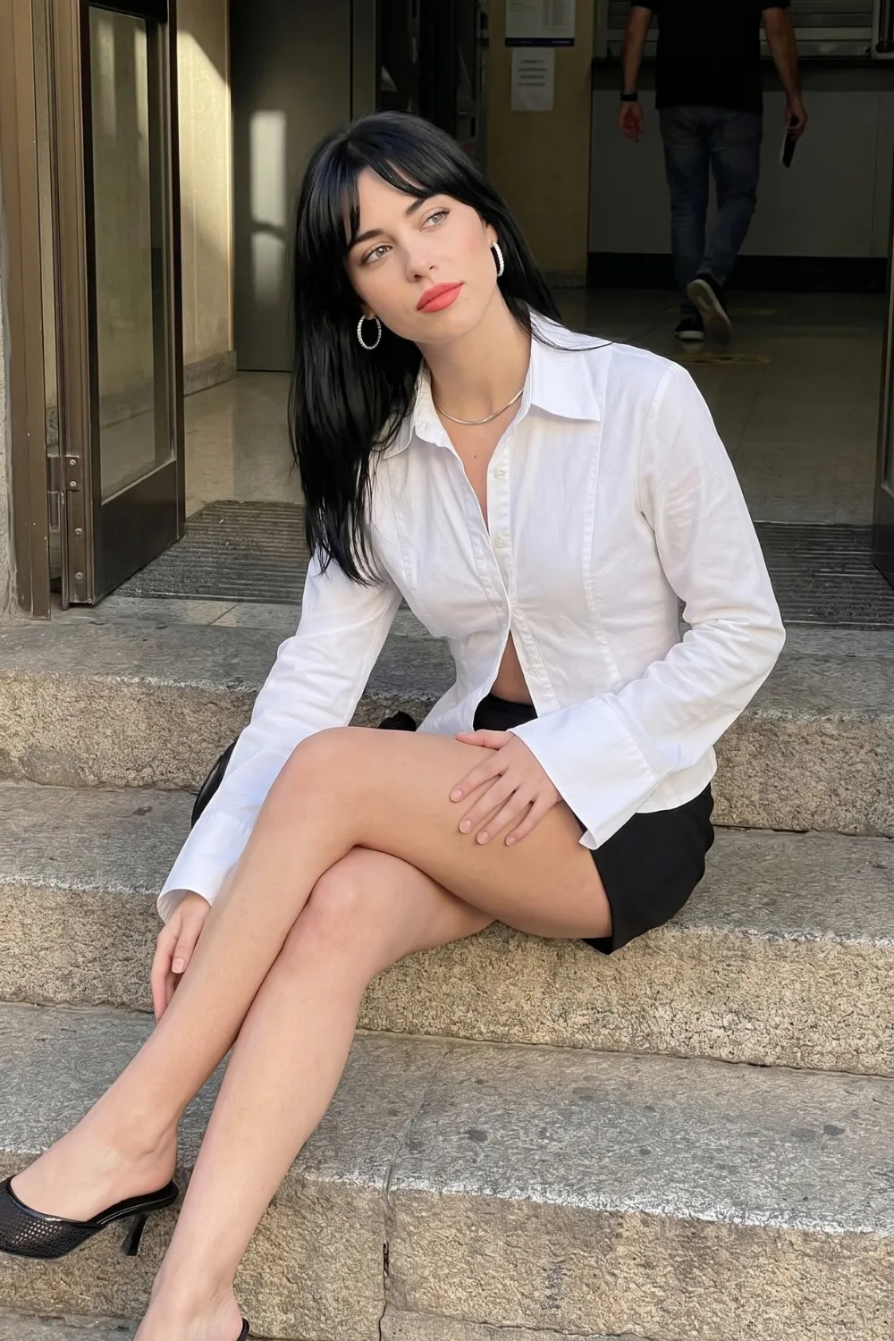 Woman in white button down crop shirt with black mini skirt