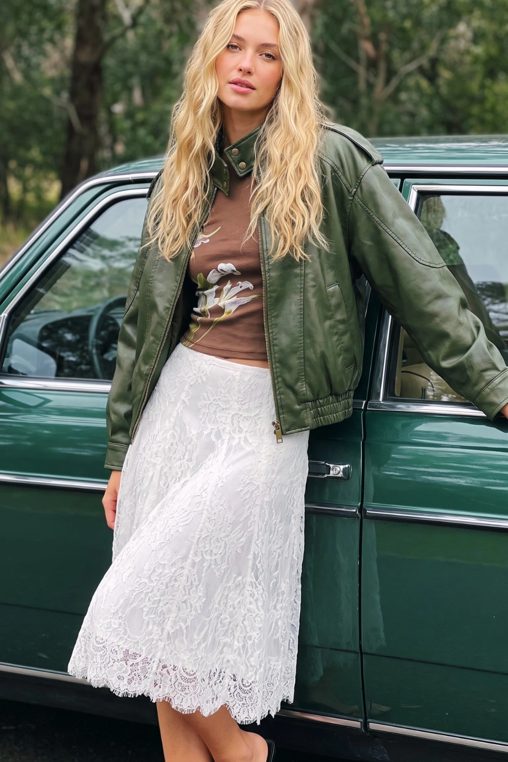 Woman in white lace midi skirt and olive green leather jacket