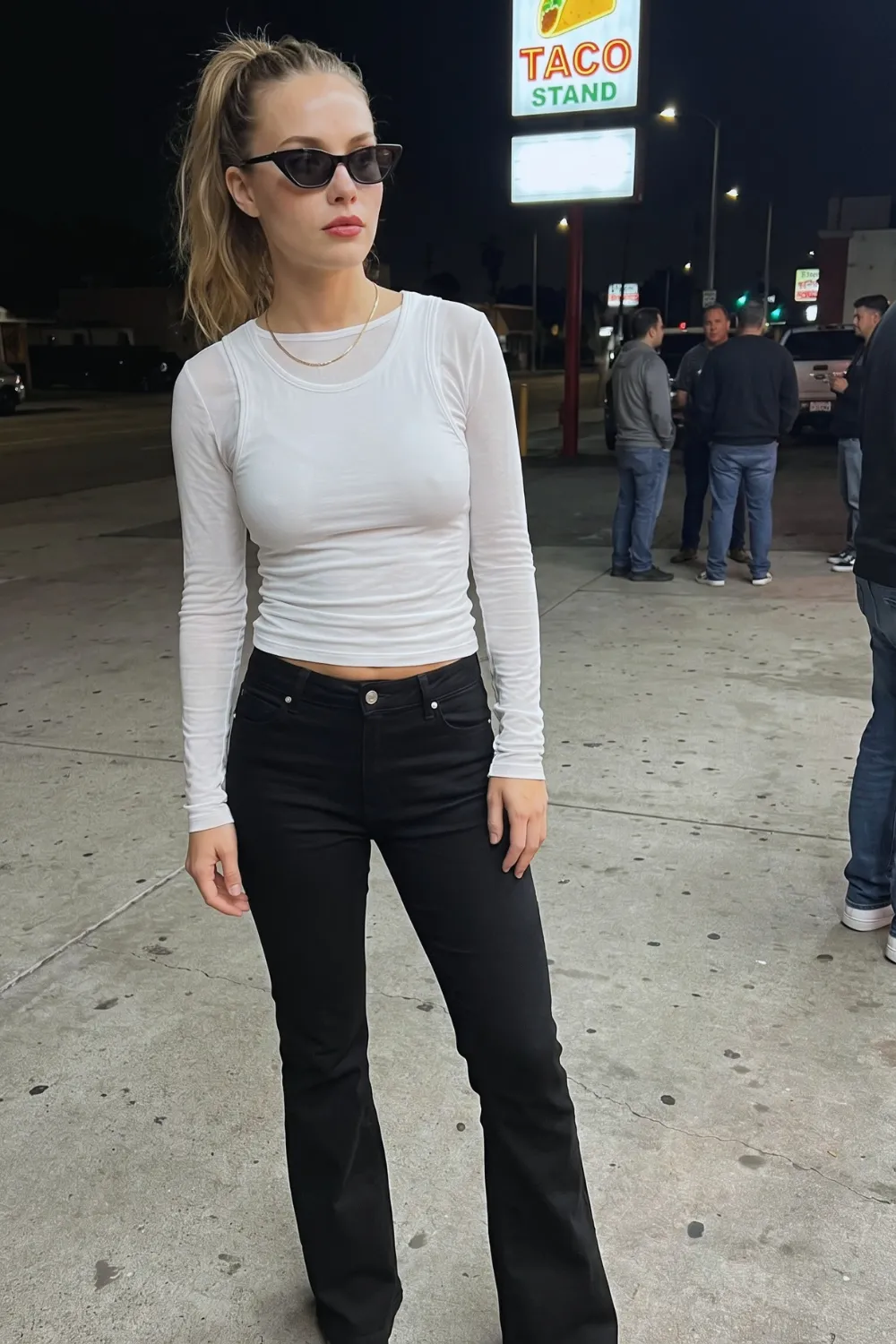 Woman in white long sleeve crop top with black high waist flare jeans