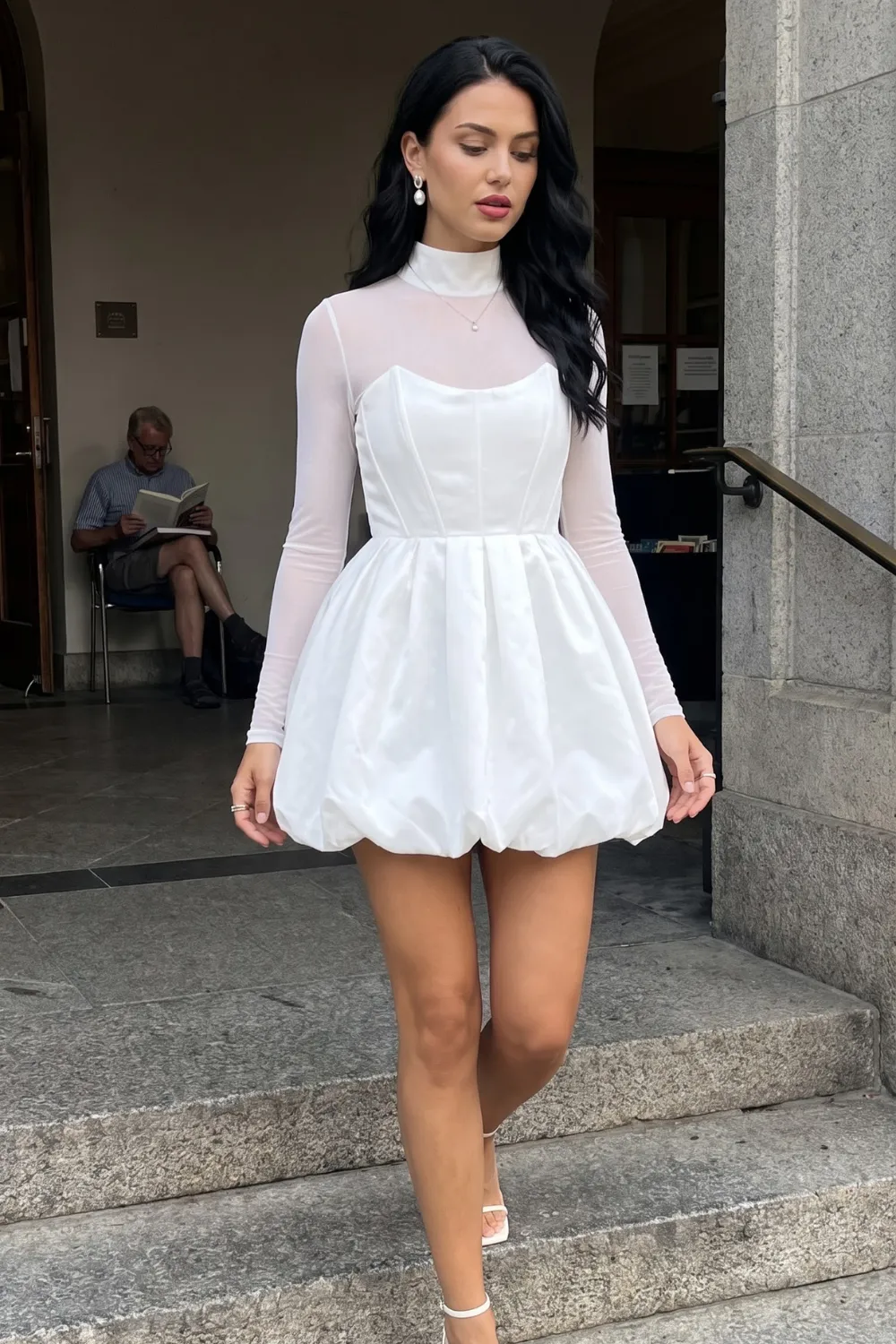 Woman in white sheer mesh long sleeve top with white satin bubble mini dress